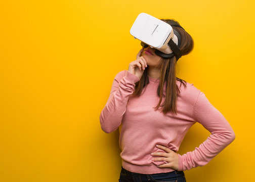 Young Cute Woman Wearing A Virtual Reality Googles Doubting And Confused