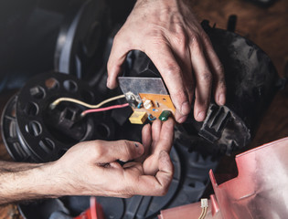 Man repairs of vacuum cleaner. Repairing