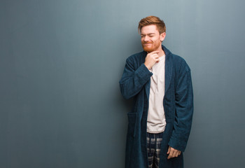 Young redhead man in pajama coughing, sick due a virus or infection
