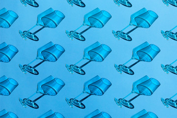 Empty wine glasses with shadow on blue background. Minimal style pattern. Art design. Top view, flat lay.