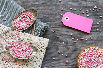 two vintage silver spoons and rusk with typical Dutch food muisjes, pink and white aniseed, for announcement birth of a daughter, baby girl