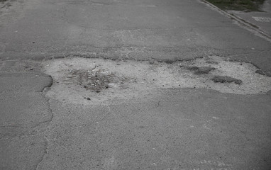  Large pit on the road. Bad roads and asphalt. Hole in the asphalt. Adangerous road.