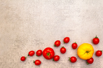 Fresh organic tomatoes. Food cooking stone background. Healthy vegetarian (vegan) eating concept, close up, top view, flat lay, copy space.