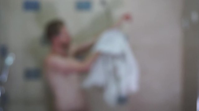 Unrecognizable young man drying off with a towel and dancing in the shower blur video