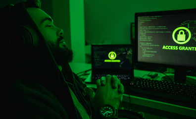 Bearded hacker relaxing near computer