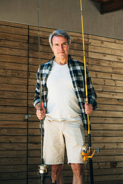 Portrait of mature man holding fishing rods