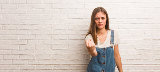 Young hipster woman showing fist to front, angry expression