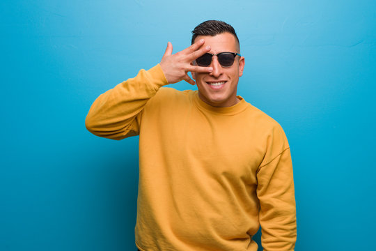 Young colombian man embarrassed and laughing at the same time
