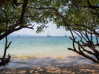White yacht floating in the turquoise sea to the island with clouds. Koh Phangan. Thailand.	