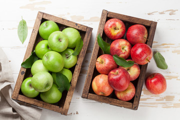 Green and red apples in wooden box