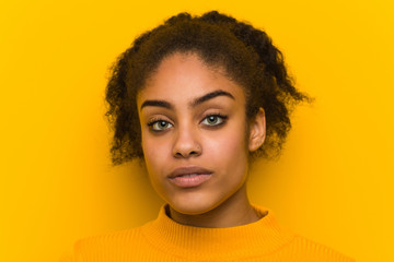 Young black woman closeup over an orange wall