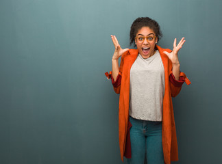 Young black african american girl with blue eyes celebrating a victory or success