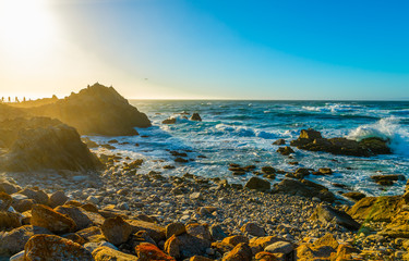 Monterey coastline near Pebble Beach Ca. on a beautiful spring day with golfers in silhouette and camera man on the rocks - obrazy, fototapety, plakaty