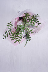 bouquet of leaves and kitchen utensils.  gift-wrapped tools as symbol of patriarchal society and gender inequality. Sexism and feminism.