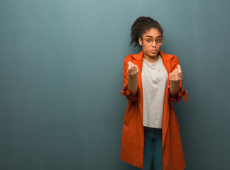 Young black african american girl with blue eyes doing a gesture of need
