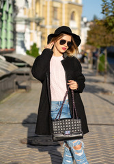 Obraz premium Street shot of elegant girl wearing hat and glasses, enjoying warm weather