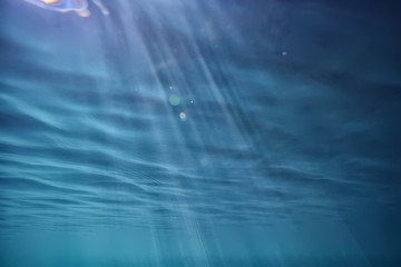 ocean water blue background underwater rays sun / abstract blue background nature water