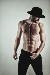 Naklejka premium Portrait of a handsome brutal man in a black hat