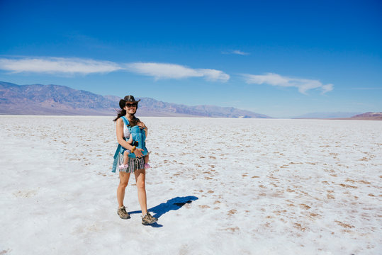 USA, California, Death Valley National Park, Badwater Basin, happy mother walking with baby girl in salt basin