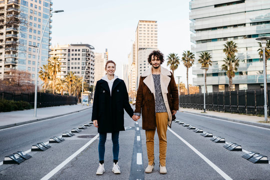 Portrait of couple holding hands in the middle of the street
