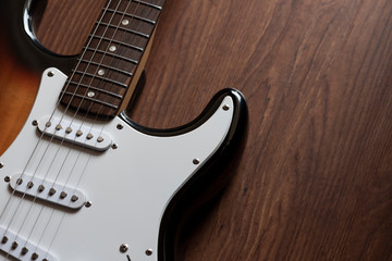 Electric guitar on the wooden background.
