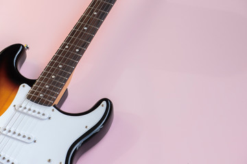 Obraz premium Electric guitar, headphones on the pink background.