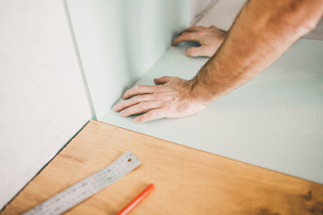 Adult man lays the laminate panel on the substrate with the technology