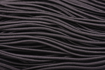 Black elastic band for sewing clothes. Sewing rubber band. Elastic for clothing texture background.