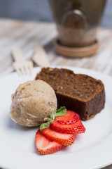 Cake, vegan ice cream and strawberries on a wooden table