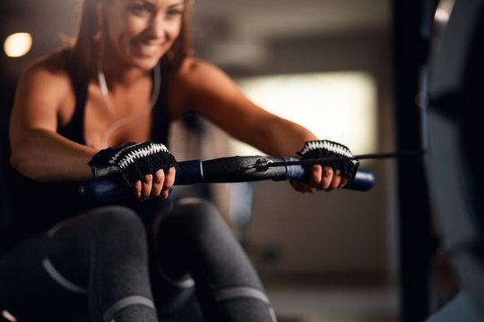 Close Up Of Sportswoman Exercising On Rowing Machine In A Gym.