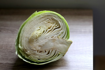 Obraz premium Half of cabbage on a wooden table. Selective focus.