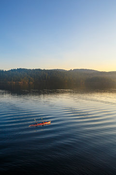Two tandem kayakers paddle into the early morning light near Harney Channel while on a 3-day sea kayaking trip in the San Juan Islands. The photo was taken from Blind Island, a small 3 acre state park near Shaw Island that offers camping opportunities to human and wind-powered boats.