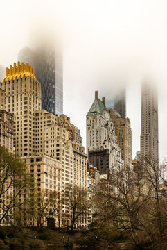 Fototapeta The skyscrapers of New York seen from Central Park hiding in the clouds