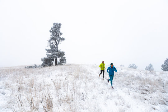 Woman and man running in winter, Idaho