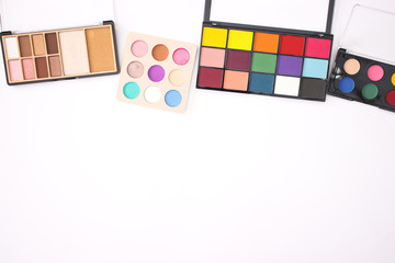 Colorful eye shadow palettes on the top of the white background 