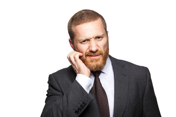 Closeup portrait of thoughtful confused handsome businessman with beard in black suit standing...