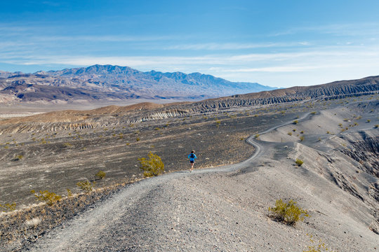 A female runner goes for a trail run around the volcanic Ubehebe Crater in Death Valley National Park in winter. The crater is known as "Tem-pin-tta- Wo?sah", by the Timbisha Shoshone Indians, which means Coyote?s Basket.