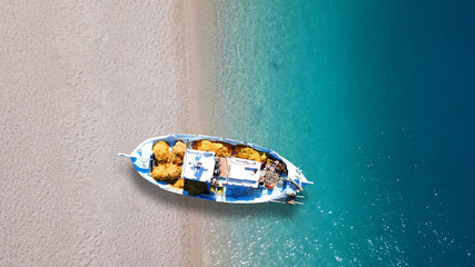 Aerial drone top view photo of red wooden traditional fishing boat in turquoise sea shore of Zakynthos island, Ionian, Greece