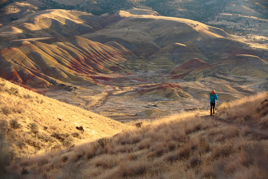 A woman trail runs along the scenic 3/4 mile Carroll Rim Trail at the Painted Hills in the John Day Fossil Beds National Monument in eastern Oregon.