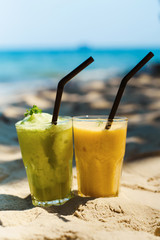 Exotic summer cocktails, shaked mix drinks and blur sandy beach on background as symbol of vacation holidays at the sea