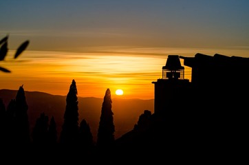 Fototapeta premium Panorama al tramonto con cielo pennellato e silhouette del paesaggio