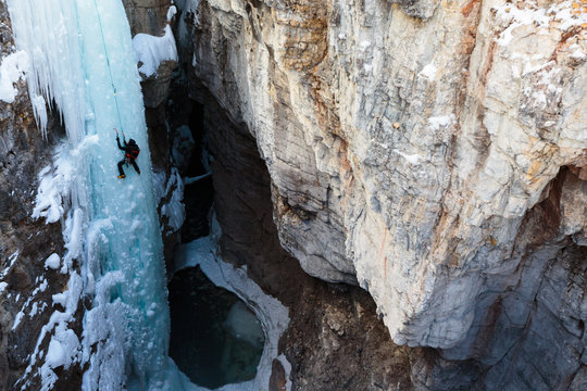 Alpine climbing legend John Roskelley climbing the 45 meter/148-foot Tokumm Pole above the Tokumm Creek in the scenic Marble Canyon, BC in Kootenay National Park near Banff, Alberta. The rugged, narrow slot canyon is a popular summer destination with the turquoise waters of Tokumm Creek flowing at the bottom. But in the winter it is a hotspot for ice climbing, snowshoeing, and nordic skiing.