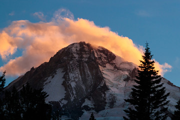Colorful wind whipped clouds over the top of Mount Hood at sunset.