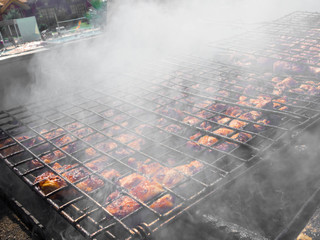 Barbeque sticks with meat, on the grill and heavy smoke above brazier