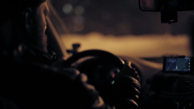 A man gets into the car and turns on the navigator on the smartphone