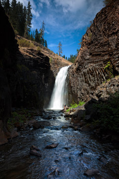 Two women escape the summer heat hiking in to the swimming below the Middle Falls at Elk Creek Falls in northern Idaho in the Nez Perce - Clearwater National Forest. The 2 mile loop trail (the remnants of an old wagon trail), takes you to Upper, Middle, and Lower Elk Creek Falls.
