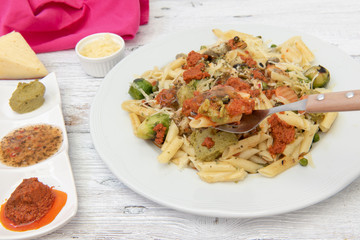 Pasta de macarrones con salsa roja, amarilla y verde.