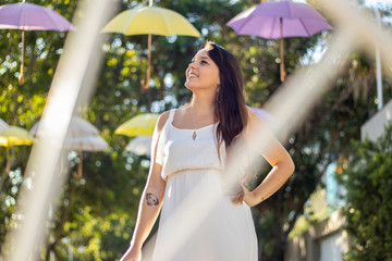 young girl in a white dress, smiling, with white bicycle wheel as photo frame and colored...