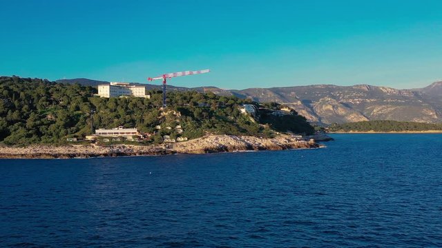 Panoramic slide along the coast line of Cap Ferrat, France into the gulf of Saint Hospice with the view to the viaduct on the road from Nice to Monako
