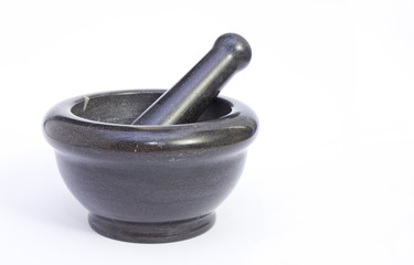 Black marble pestle and mortar on white background on left.